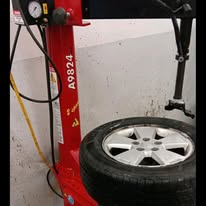 Red tire-changing equipment inside Golden Rule Tire